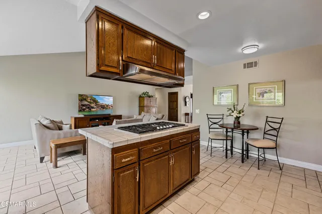 a kitchen with stainless steel appliances granite countertop a stove a sink dishwasher a refrigerator and cabinets with wooden floor