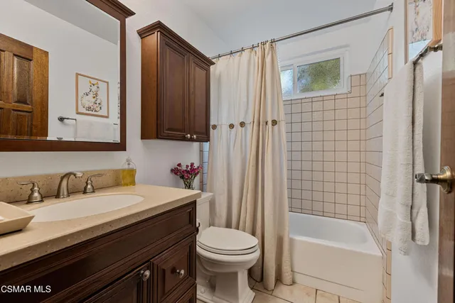 a view of a patio with table and chairs potted plants and a large tree