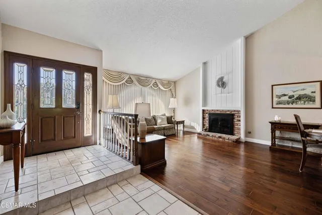 a living room with fireplace furniture and a wooden floor