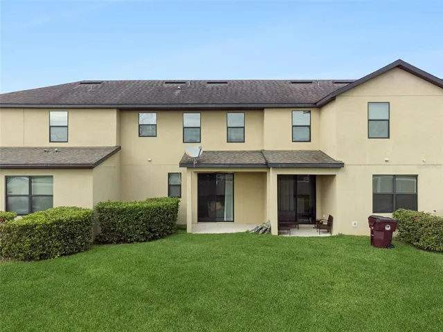 a view of a house with brick walls and a yard with potted plants