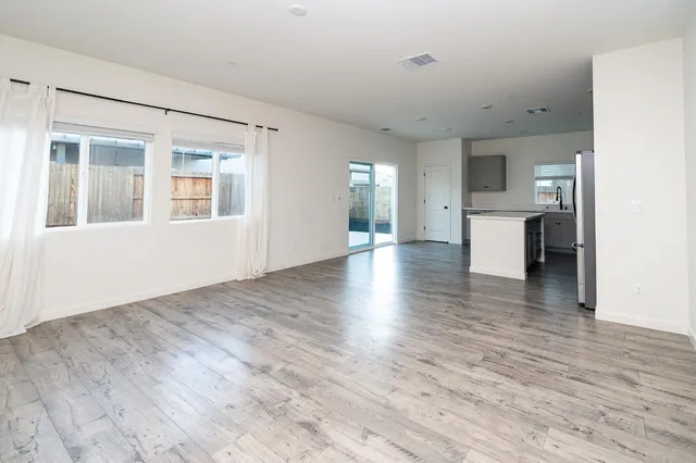 a view of a kitchen with a sink and dishwasher a refrigerator with wooden floor