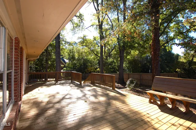 a view of backyard with a large tree and wooden fence