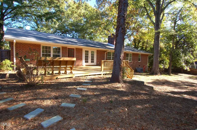 a front view of a house with a yard tree and outdoor seating