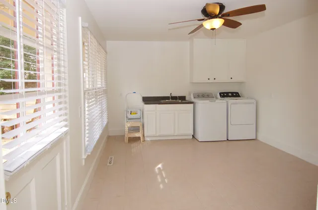 a kitchen with stainless steel appliances a white stove top oven a sink a chimney and a window