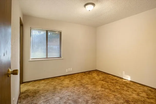 an empty room with windows and closet