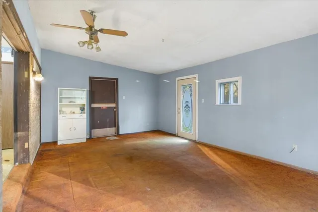 an empty room with windows and cabinet