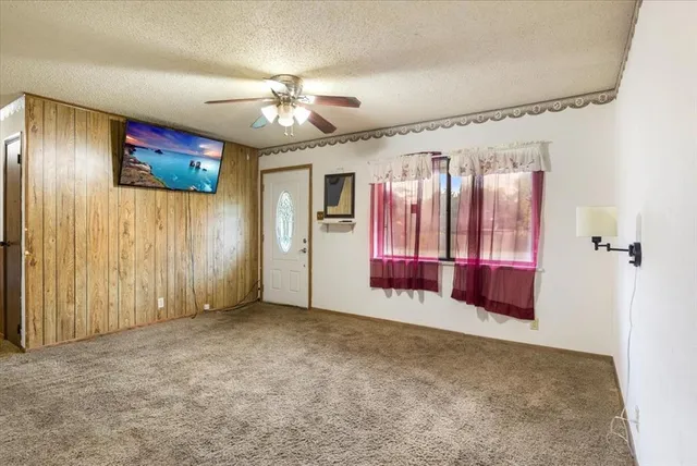 an empty room with fan and windows