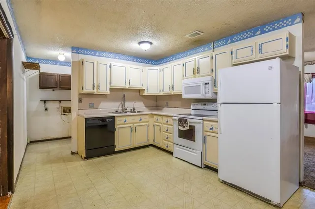 a kitchen with white cabinets and white stainless steel appliances