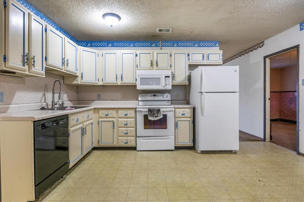 12379 Chapman Road Tyler, TX 75708 - Photo 8 of 40 a kitchen with stainless steel appliances granite countertop a refrigerator sink stove and cabinets