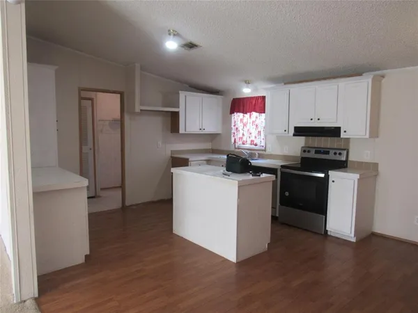a kitchen with granite countertop a stove top oven sink and cabinets