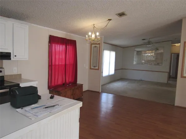 a view of a kitchen with granite countertop a sink dishwasher a stove and a refrigerator with wooden floor