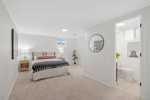 a bedroom with a bed a mirror and a window