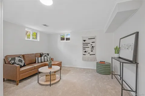 a living room with furniture a wall paintings and a window
