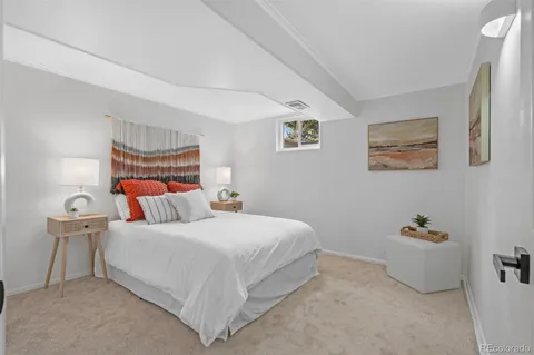 a bedroom with a bed and a lamp on the dresser