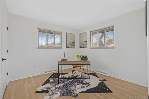 a workspace room with wooden floor and windows