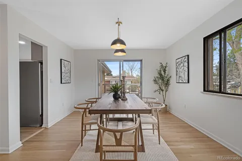 a dining room with chandelier and wooden floor