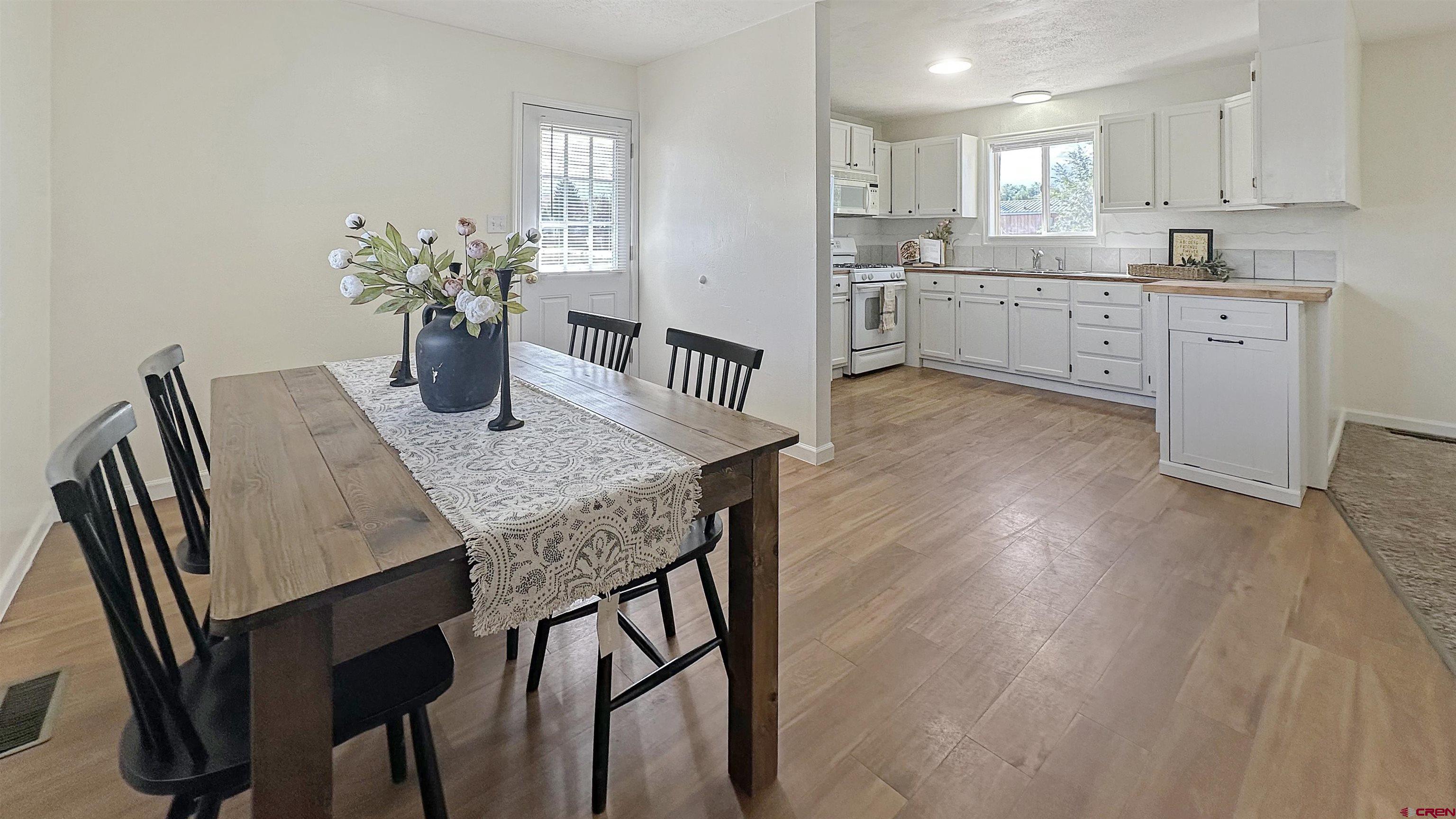 629 Norwood Road Montrose, CO 81403 - Photo 8 of 38 a open dining room with stainless steel appliances kitchen island granite countertop furniture wooden floor and a kitchen view