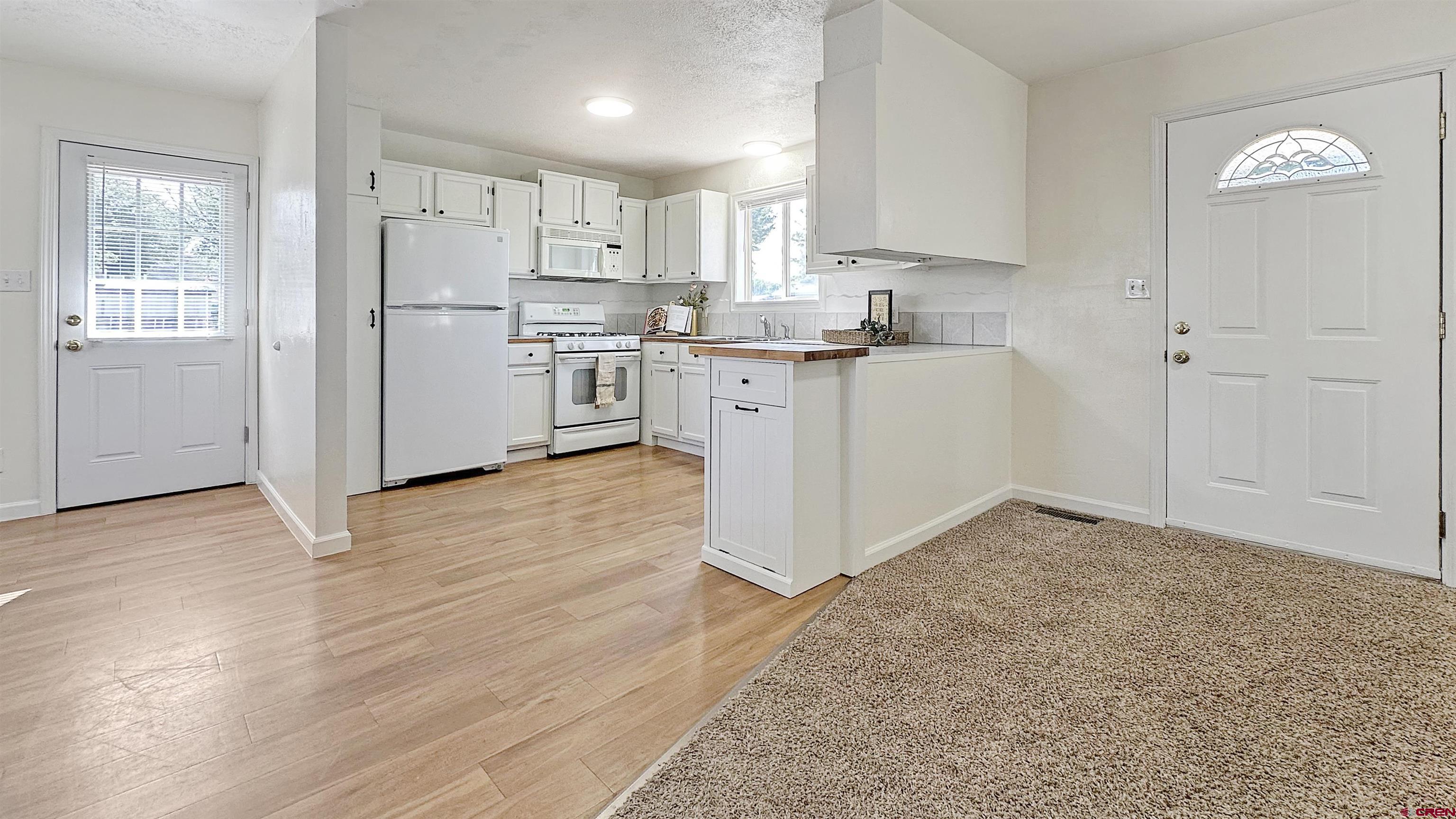 629 Norwood Road Montrose, CO 81403 - Photo 10 of 38 a kitchen with refrigerator cabinets and wooden floor