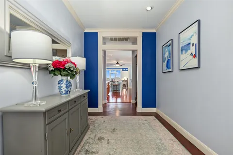a hallway with a chandelier and mirror