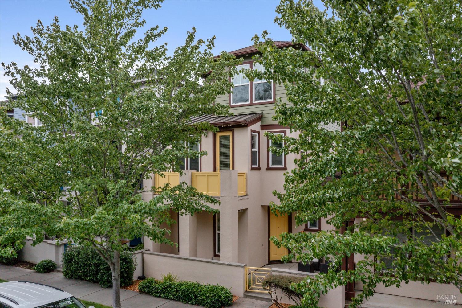 a view of a white house next to a tree