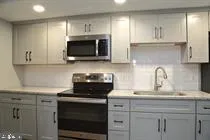 a kitchen with sink a microwave and cabinets