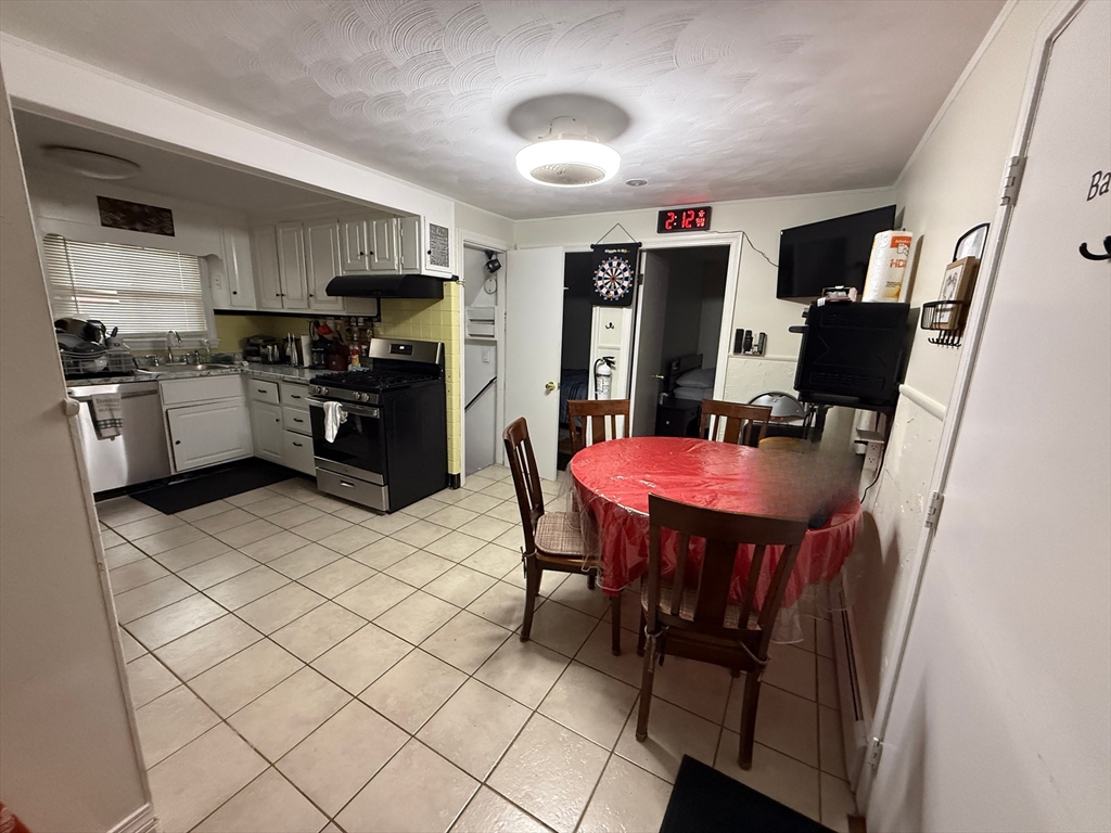 41 Shurtleff Street Revere, MA 02151 - Photo 5 of 12 a kitchen with stainless steel appliances a refrigerator a stove a sink dishwasher and a dining table with wooden floor
