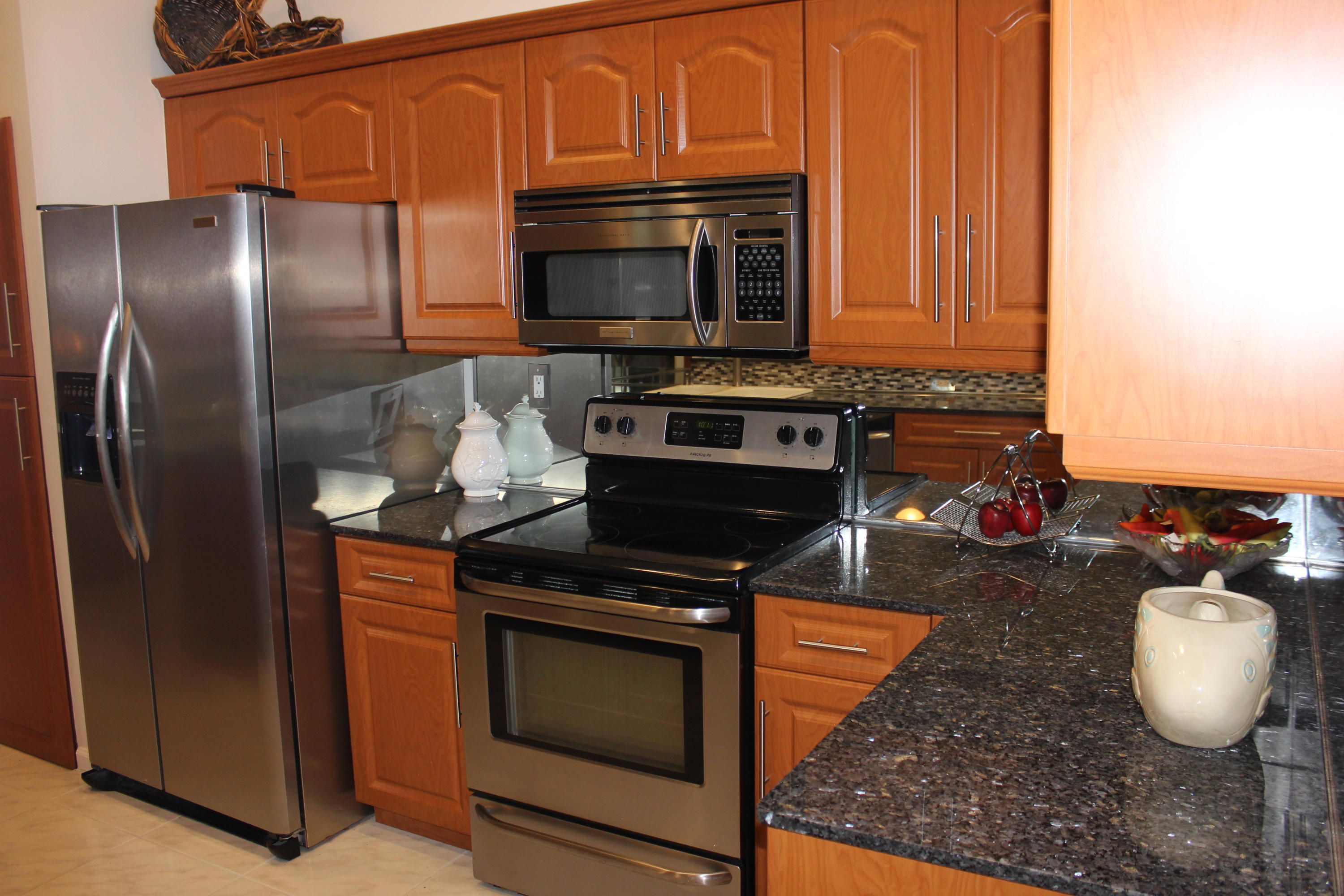 2671 Northwest 49th Street Boca Raton, FL 33434 - Photo 20 of 47 a kitchen with stainless steel appliances granite countertop a stove microwave and refrigerator