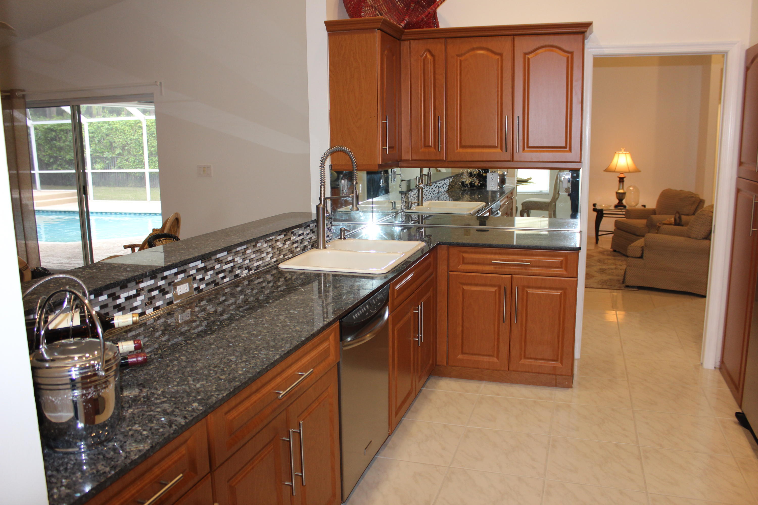 2671 Northwest 49th Street Boca Raton, FL 33434 - Photo 21 of 47 a kitchen with granite countertop a sink stove and cabinets