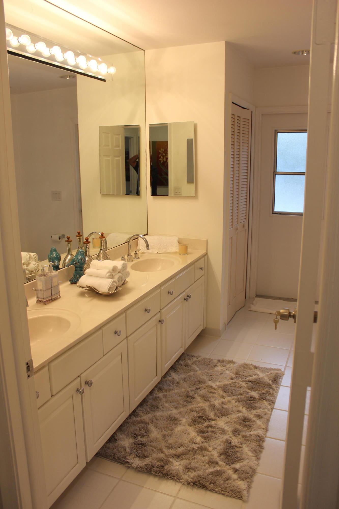 2671 Northwest 49th Street Boca Raton, FL 33434 - Photo 37 of 47 a bathroom with a double vanity sink and mirror