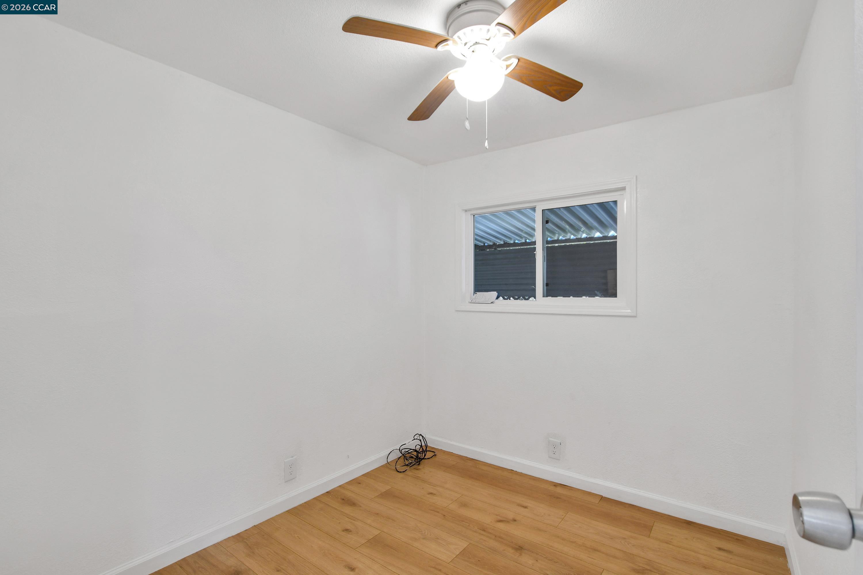 237 Orangevale Pittsburg, CA 94565 - Photo 10 of 21 an empty room with wooden floor chandelier fan and windows