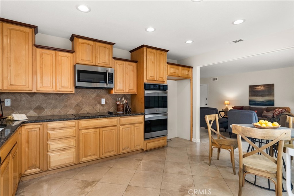 1902 East Eucalyptus Lane Brea, CA 92821 - Photo 10 of 41 a kitchen with stainless steel appliances granite countertop a stove a sink a microwave a dining table and chairs