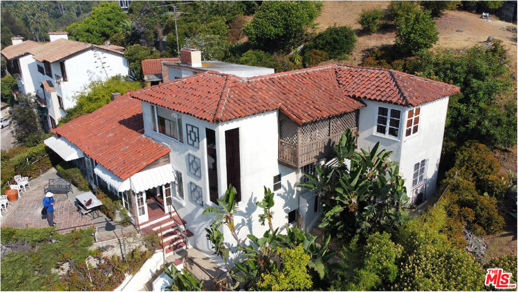 a aerial view of a house with a yard table and chairs