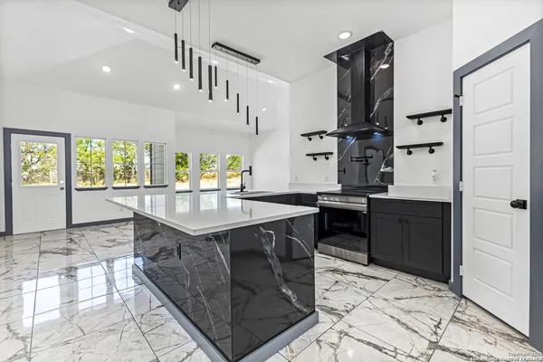 a kitchen with stainless steel appliances granite countertop a sink stove and cabinets