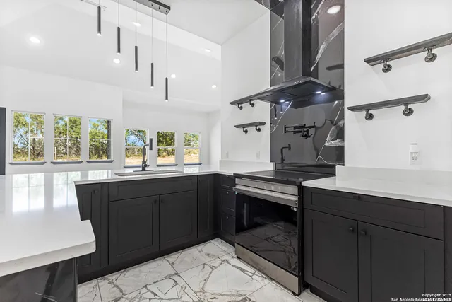 a kitchen with granite countertop a sink cabinets and wooden floor