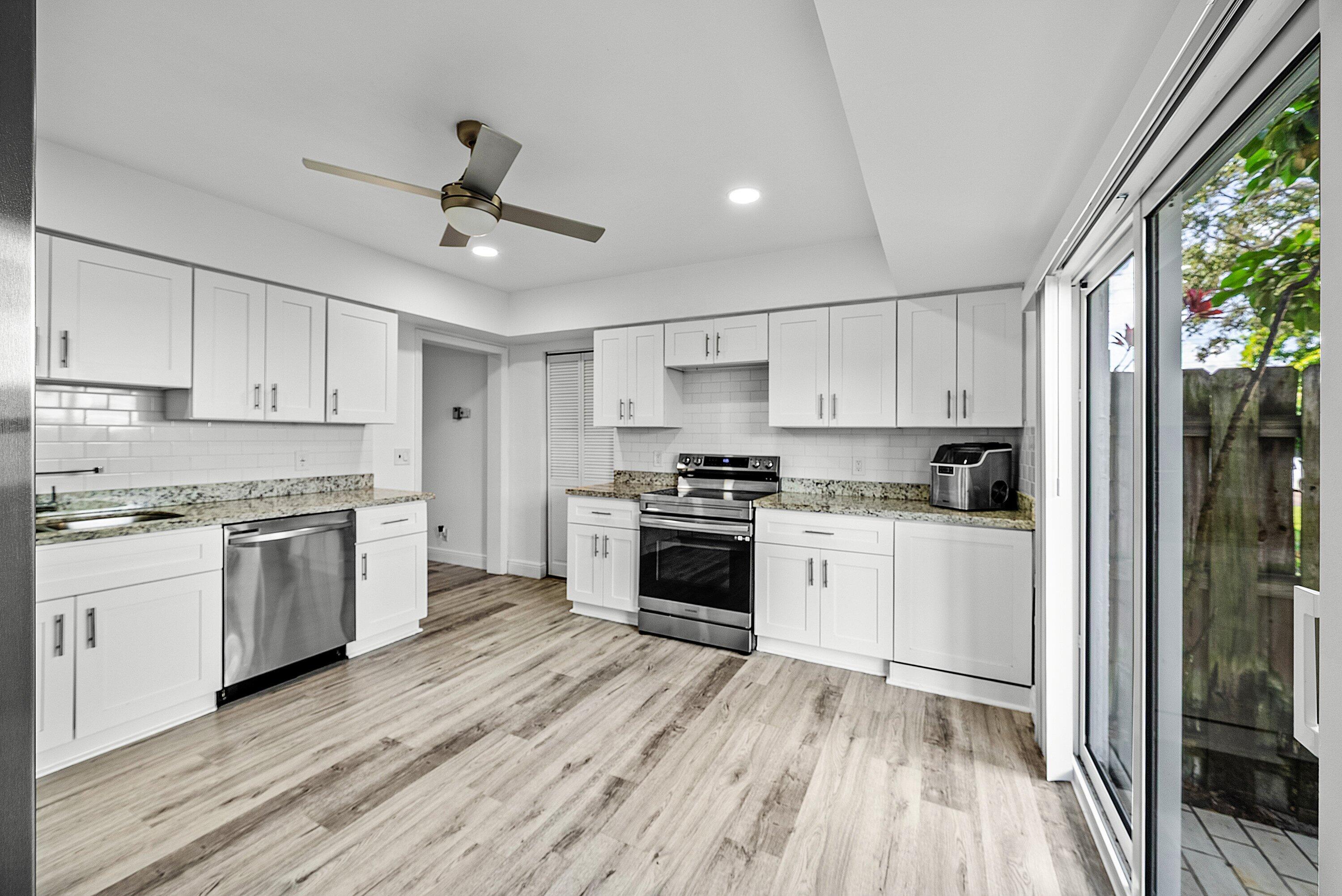 6165 Old Court Road, Unit 123 Boca Raton, FL 33433 - Photo 2 of 30 a kitchen with granite countertop white cabinets a sink a window and stainless steel appliances