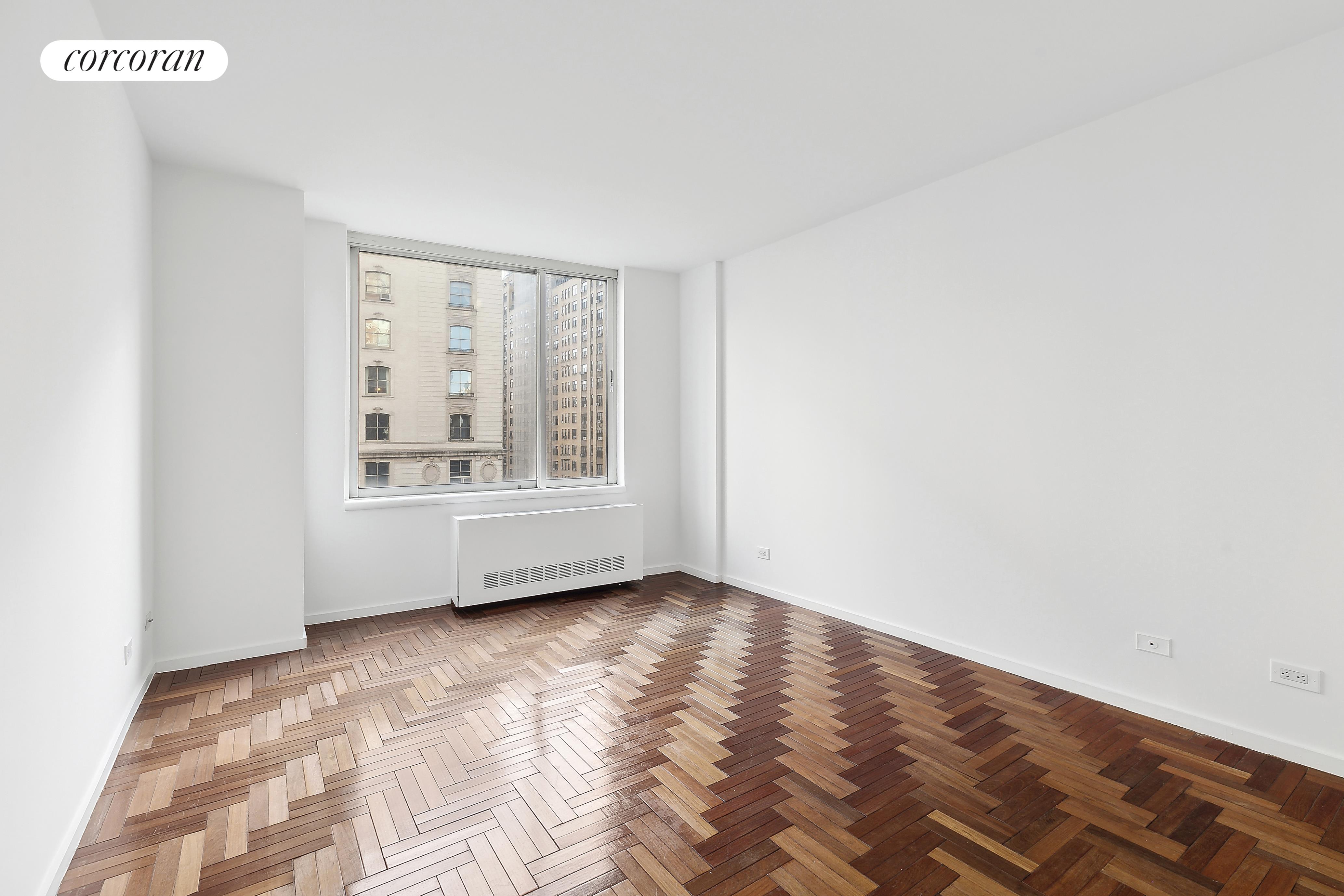 2373 Broadway, Unit 705 Manhattan, NY 10024 - Photo 10 of 13 a view of an empty room with wooden floor and a window