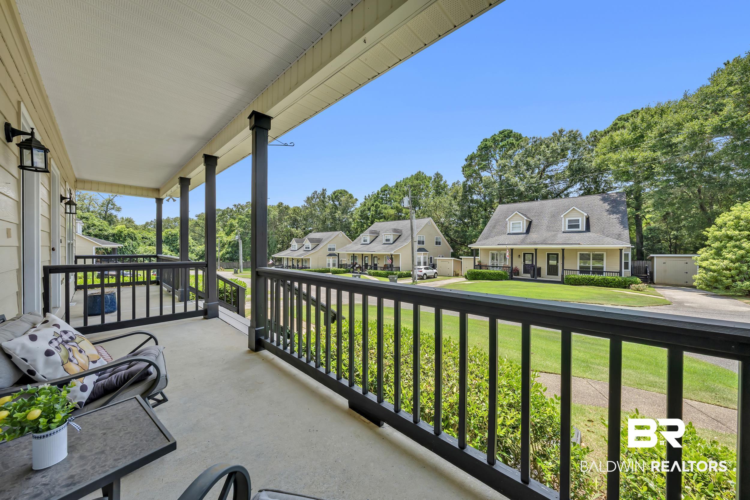 17488 Pandion Ridge, Unit A1 Fairhope, AL 36532 - Photo 4 of 18 Expansive covered porch with concrete flooring and dark-toned railings