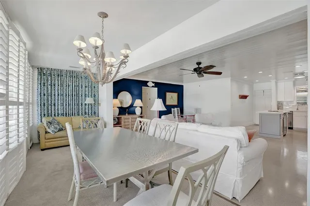 a view of a dining room with furniture a chandelier and window