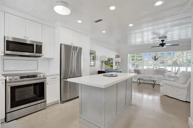 a kitchen with a sink stainless steel appliances and white cabinets