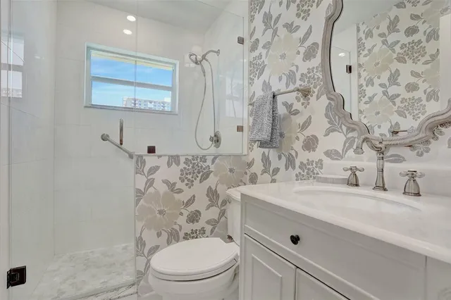 a bathroom with a granite countertop toilet sink and mirror