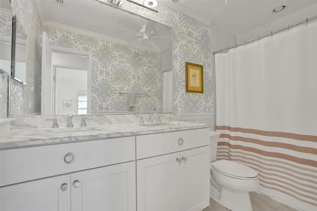 a bathroom with a granite countertop toilet sink and mirror