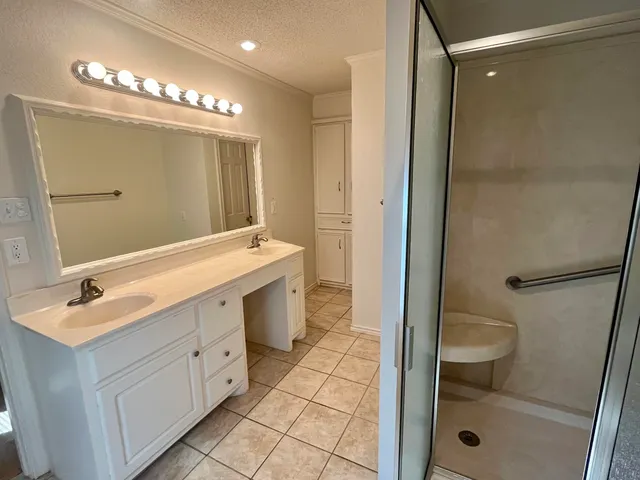 a bathroom with a double vanity sink a toilet a mirror and shower