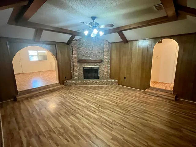a view of a livingroom with wooden floor and a ceiling fan