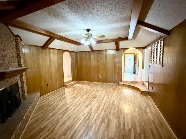 a view of an empty room with a fireplace and a chandelier