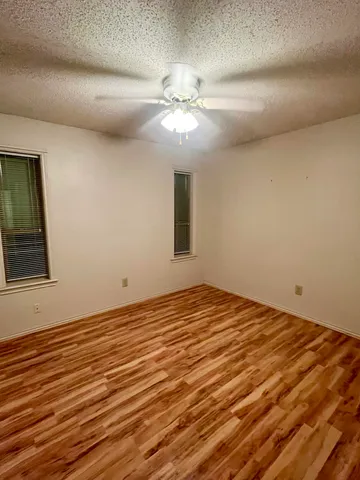 a view of a room with wooden floor and a ceiling fan