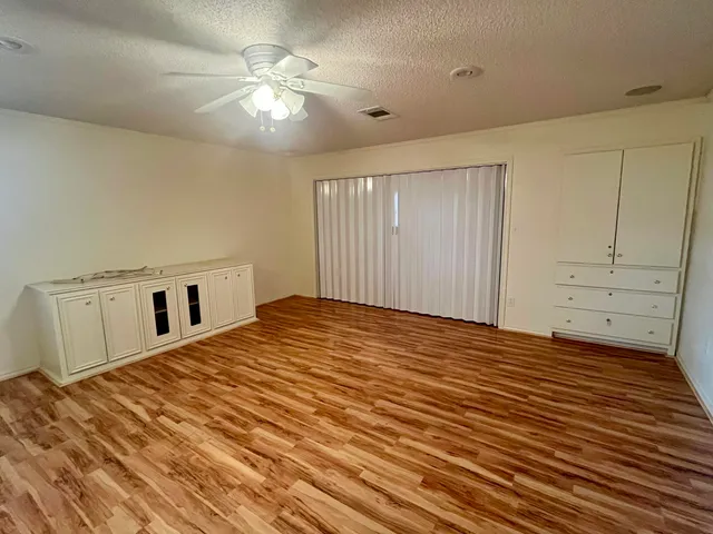 a view of a bedroom with closet and ceiling fan