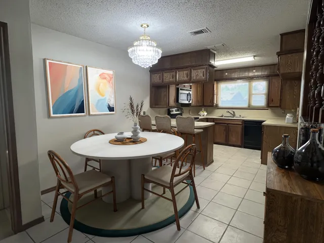 a view of a dining room with furniture and chandelier