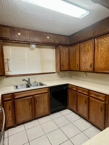 a kitchen with granite countertop a sink and cabinets