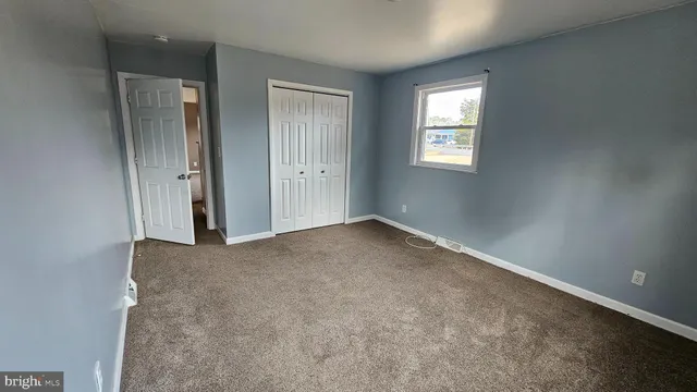an empty room with windows and closet