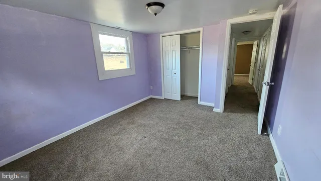 an empty room with windows and closet